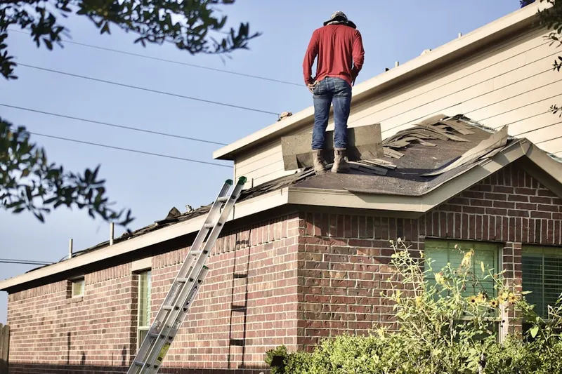 Professional roofer working on a residential roof in Malden